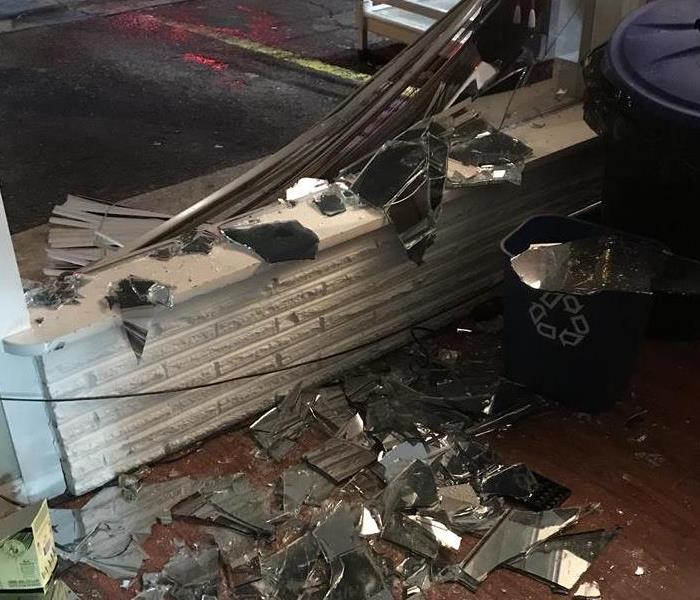 Local business with front window broke out, glass and debris strung through the inside